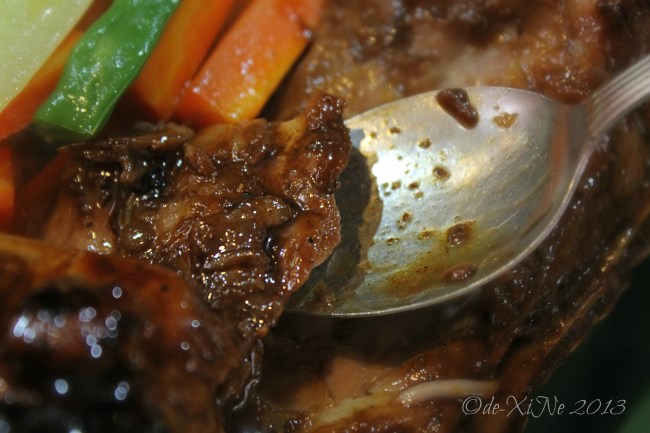 Beggang Resto Grill slicing meat away from the spare ribs with a spoon