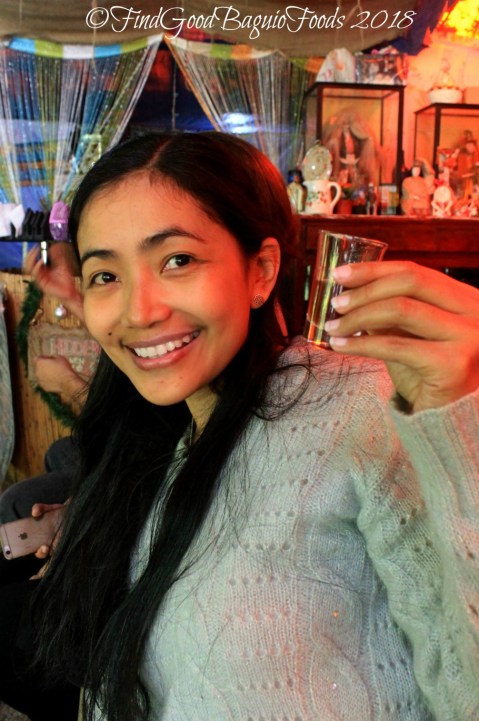 X getting a shot of tapuy at the DTI Ifugao food tasting 2018